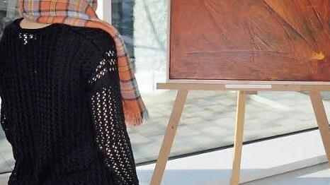 Eine Ausstellungsbesucherin betrachtet das Bild von Dennis Wolter mit dem Titel "Lichtwirbel". Foto: Andrea Spörlein