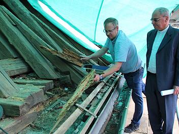 Statiker Thomas Leyh (links) und Dekan Kilian Kemmer schauen sich die vom gescheckten Nagekäfer zerfressenen Balken am Dachstuhl der Höchstadter Georgskirche an. Foto: Andreas Dorsch