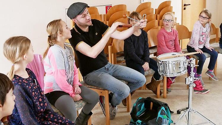Interessiert lauschten die Kinder den Erklärungen des Schlagzeugers des Blasorchester Sand, Florian Rückert. Foto: Nadine Rippstein