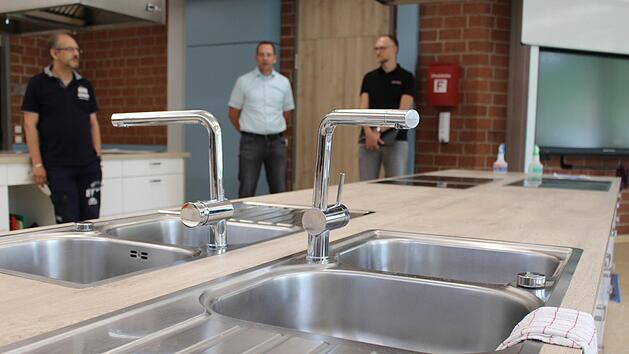 Im bereits sanierten Teil der Schule befindet sich die neue, komfortable  Lehrküche. Konrektor Marco Genzler, Rektor Michael Heyne und Ingenieur Bastian Wagner erklären die Vorteile. Foto: Julia Raab