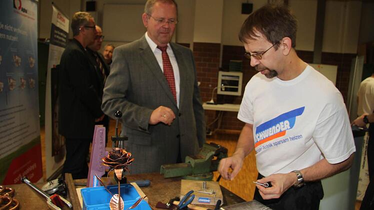 Die Ausbildungsmesse ist auch für Erwachsene interessant. Henry Schulz von der Arbeitsagentur versucht, eine Pfeife aus Zinn zu biegen. Foto: Sonja Adam