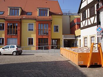 Hier geht es derzeit ins Haus St. Bruno. An der Fuchsgasse liegt der provisorische Eingang zum Altenheim (rechts, der Durchgang). Links ist der Flügel, in dem Sozialstation, Ehe-, Familien- und Lebensberatung sowie der Sozialdienst Katholischer Frauen zu finden sind. Rechts, wo gerade der Bauschutt-Container steht, wird der Pflasterbelag der Fuchsgasse ausgetauscht und so ein besser begeh- und befahrbarer Zugang geschaffen, sobald der Boden frostfrei ist.  Sabine Weinbeer