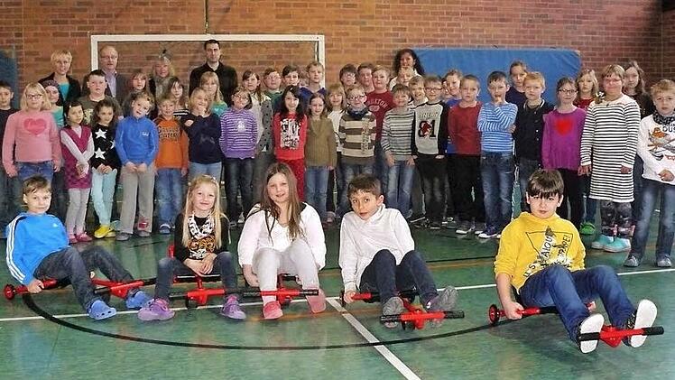 Mit den neuen Swing-Rollern werden die Marktleugaster Schüler viel Spaß im Sportunterricht und in der Pause haben. Unser Bild zeigt die Schülerinnen und Schüler der zweiten und vierten Marktleugaster Grundschulklasse zusammen mit (hinten von links) Ramona Fichtner, Siegfried Sesselmann, Karin Müller, Marc Hartenberger und Annette Marx bei der Übergabe in der Schulturnhalle.  Foto: Foto: kpw