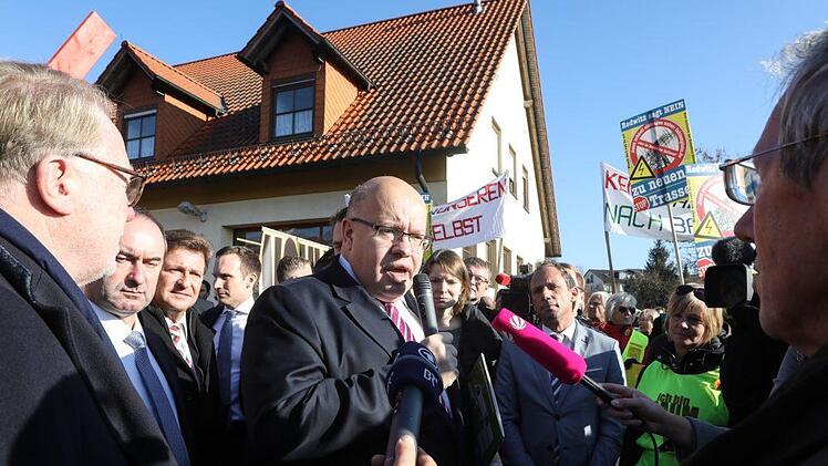 Altmaier von Journalisten und Demonstranten umringt.