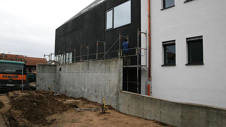 Vor die Mauer wird der Berliner Bär gestellt: In Strullendorf reibt man sich die Augen über eine Betonwand, die eine Rollstuhlrampe vom Bürgersteig der Forchheimer Straße abtrennen soll. Im Hintergrund der Rathaus-Anbau mit anthrazitfarbener Betonverkleidung.  Foto: Werner Baier