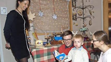 Im Eingangsbereich der Friedenskirche betrachtet eine junge Familie ein Kinderbuch. Die Geschenkecke war Teil eines Adventsbasars, den der Kirchenbauverein mit seiner Vorsitzenden Susanne Blaßdörfer (links) ausrichtete. Foto: Stefan Geiger
