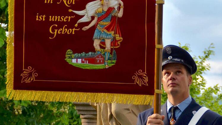 Gottesdienst an der Siebenschmerzkapelle: Die neue Standarte der Wollbacher Wehr wurde gesegnet. Matthias Rottenberger hält sie.  Foto: Kathrin Kupka-Hahn