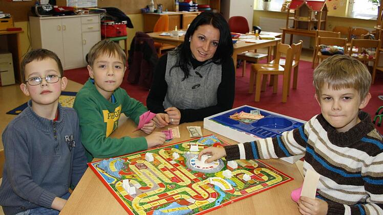 Kindergartenleiterin Alexandra Wirth (Mitte) spielt mit den Hortkindern Daniel (von links), Richard und Matthias. Foto: Ralf Ruppert