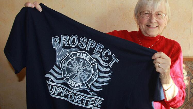 Rosie Jenkins mit einem T-Shirt der Feuerwehr ihres Heimatortes Prospect/Oregon. Drei solche Shirts hat sie mitgebracht, um sie an ihre Birkacher Verwandten Bernhard und Thomas Waidhas sowie an Kreisbrandinspektor Gerhard Elflein zu verschenken. Fotos: Matthias Einwag