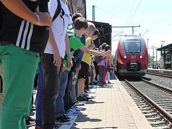 Schüler stehen in Kronach dicht am Gleisbett während der Zug einfährt. Foto: Jan Koch