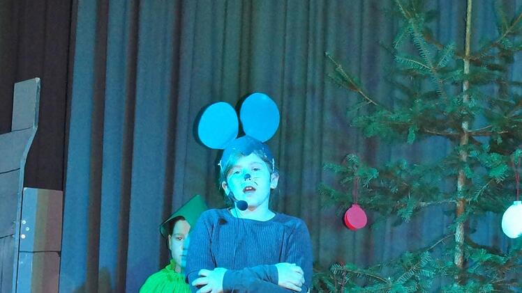 Auch die kleine Maus, dargestellt von Alina Lang aus der dritten Klasse, hängt einen Zettel an den Wunschbaum. Sie wünscht sich einen richtigen Freund und ein großes Stück Käse. Foto: Johanna Eckert