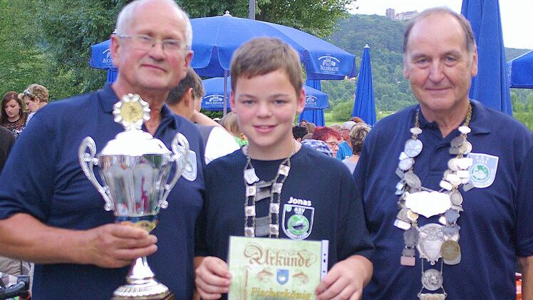 ASV-Vorsitzender Kurt Fröhlich überreichte den neuen Fischerkönigen der Jugend, Jonas Ulsamer, und der Erwachsenen, Wolfgang Ulried (von links), die Königskette und den Pokal. Foto: Winfried Ehling