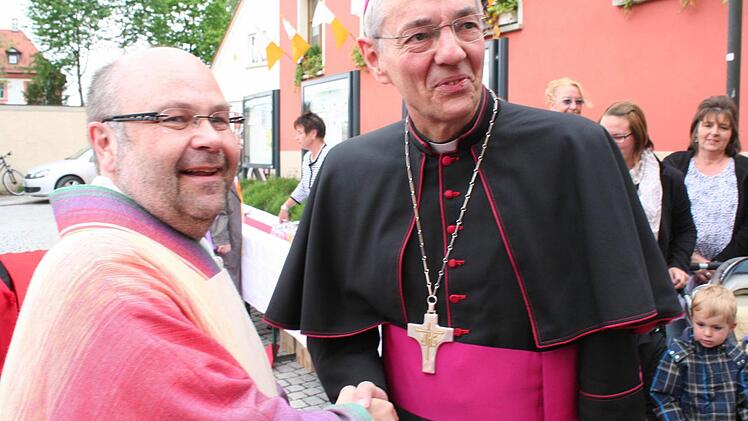 Pfarrer Wolfgang Eßel (links) heißt den Erzbischof willkommen