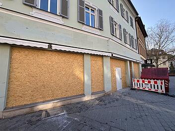 In der Bamberger Innenstadt sind Schaufenster eines Geb&auml;udes mit Holzplatten verkleidet. Bald zieht dort eine bekannte Kette ein. Neben der Baustelle steht ein roter Container.