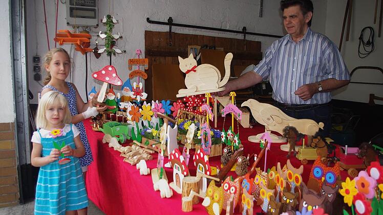 Peter Löffler aus Steinberg zeigt der vierjährigen Karla und ihrer vier Jahre älteren Schwester Anne seine kleinen Kunstwerke. Foto: Heike Schülein