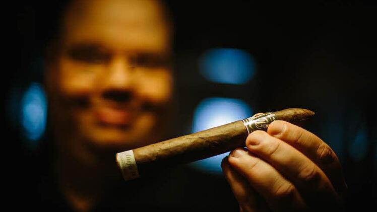 Michael Scholz zeigt seine Lieblingszigarre, eine "Anejo 18". Das Deckblatt der Zigarre mit brasilianischem Tabak wurde in den 90er Jahren geerntet. Foto: Hendrik Steffens