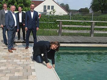 Wie ist das Wasser? "Angenehm erfrischend", meinte die Bundespolitikerin Manuela Rottmann, die das Natur-Freibad Aura mit Anerkennung bedachte. Zuschauer beim "Wassertest" sind DVS-Moderatoren Moritz Kirchesch und Stefan Kämper sowie Landrat Thomas Bold und Bürgermeister Thomas Hack.