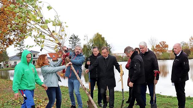 Angelika K&ouml;nig und Michael Auer hieven den Baum ins Loch. Foto: Blum