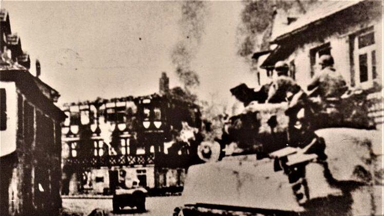 Der erste Shermann-Panzer in den Straßen der Stadt Kronach; im Hintergrund der lichterloh brennende Fachwerkbau "Goldener Wagen" (jetzt Weka) mit  eingestürztem DachRepro: G. Fleischmann