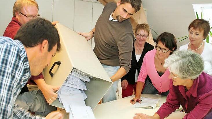 Josef Peßler (etwas verdeckt) und Matthias Bangert kippen den Inhalt der Urne aus. Weiter von links Roman Lorz, Gerlinde Heinzmann, Sigrid Kaiser, Ursula Hubert, Ruth Bechstein.  Foto: Evi Seeger