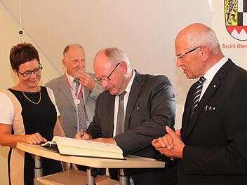 Eberhard Hofmann (Mitte) trägt sich ins Goldene Buch ein - unter den Augen von Anja Gebhardt, Otto Siebenhaar und Günther Denzler. Die Bürgermeisterin nahm dies zum Anlass, nachzuschauen, wer sich noch alles im Laufe der Jahre darin unterschrieben hat. Foto: Carmen Schwind