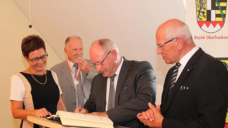 Eberhard Hofmann (Mitte) trägt sich ins Goldene Buch ein - unter den Augen von Anja Gebhardt, Otto Siebenhaar und Günther Denzler. Die Bürgermeisterin nahm dies zum Anlass, nachzuschauen, wer sich noch alles im Laufe der Jahre darin unterschrieben hat. Foto: Carmen Schwind