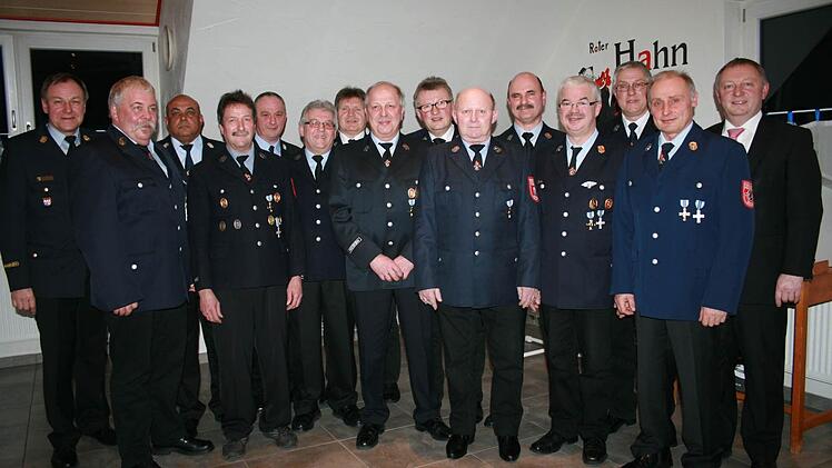 Kreisbrandrat Benno Metz (links) und Landrat Thomas Bold (rechts) gratulieren den Feuerwehrmännern mit 40 Jahren Dienstzeit.