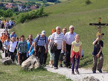Mit dem Kreuz voran wandern zahlreiche Gläubige auf das Walberla. Fotos: Galster