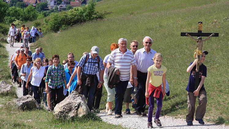 Mit dem Kreuz voran wandern zahlreiche Gläubige auf das Walberla. Fotos: Galster