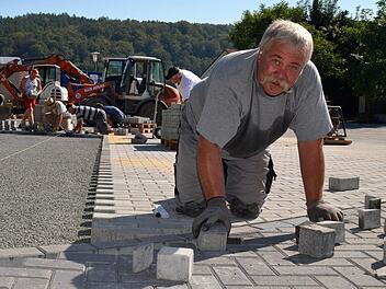 Puzzlearbeit: Norbert Wegemer ist hier dabei, Pflastersteine entlang der kurvigen Zufahrt zu verlegen. Seine Mitstreiter im Hintergrund hingegen haben es etwas einfacher. Sie können das Pflaster einfach so, ohne große Hindernisse verlegen. Foto: Kathrin Kupka-Hahn