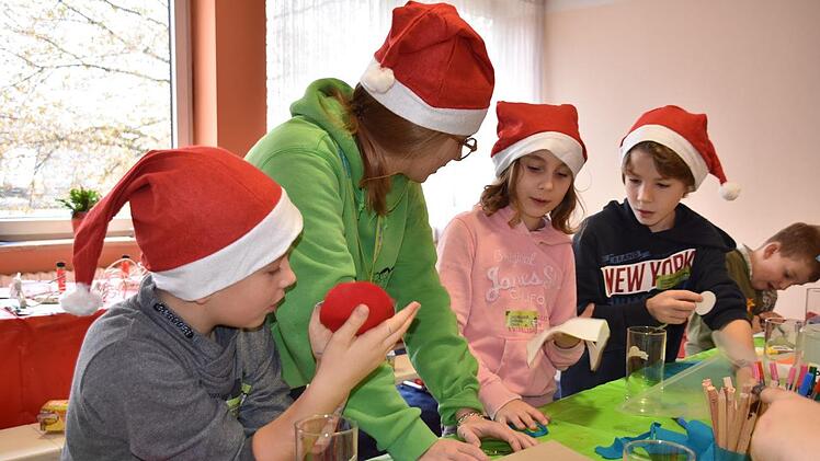 Matteo, Greta und Yannick bastelten mit Betreuerin Luzie ein Windlicht. Foto: Uschi Prawitz