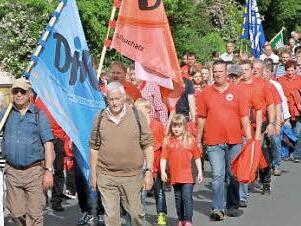 Mit bunten Fahnen ziehen die Teilnehmer zum Kreuzberg.  Foto: Erlwein