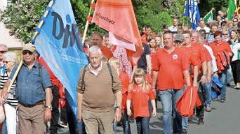 Mit bunten Fahnen ziehen die Teilnehmer zum Kreuzberg.  Foto: Erlwein