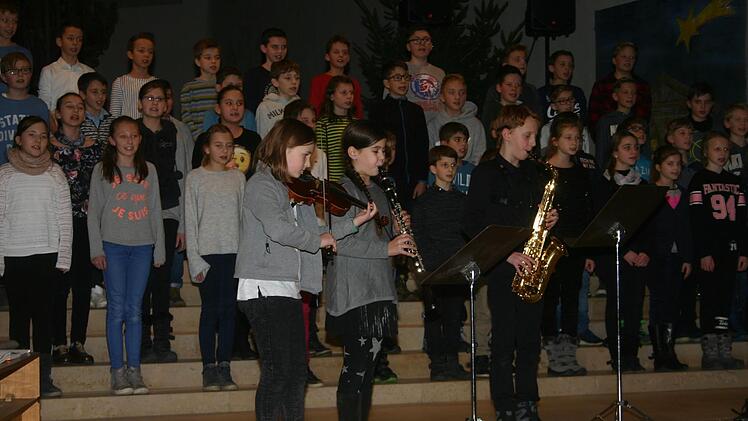 Mit "Leise rieselt der Schnee" bereicherte der Chor der fünften Klassen die Weihnachtsfeier des Ernestinums. Begleitet wurden die jungen Sängerinnen und Sänger von den Fünftklässlern Lias Cogan (Geige), Alisa Knörnschild (Klarinette) und Christian Drese (Saxophon). Foto: Martin Rebhan