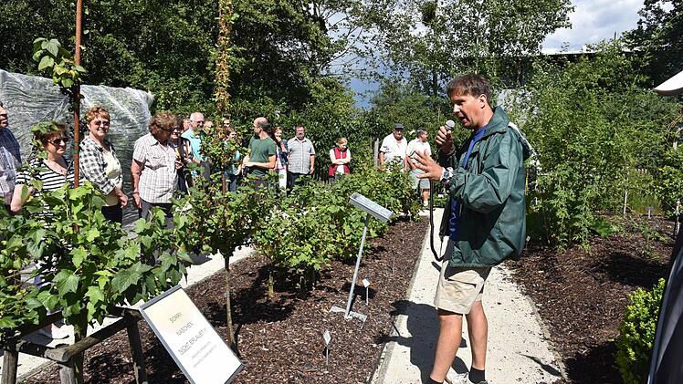 Kreisfachberater Thomas Neder führt beim Sommerfest durch den Kreislehrgarten und gibt Tipps zum Anbau.