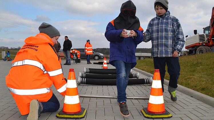 Vertrauen und eine ruihige Hand sind hier gefragt. August Kleinhenz führt hier seinen vermummten Bruder Anton über eine Hindernisstrecke, die er ohne Wasser zu verschütten überwinden muss. Foto: Kathrin Kupka-Hahn