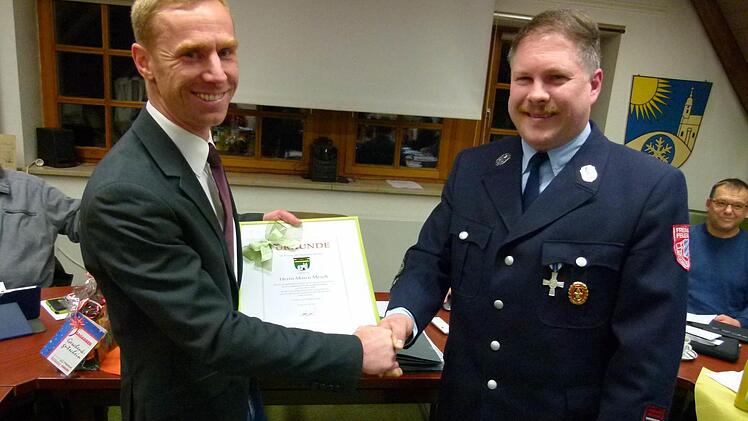 "Sie haben uneigennützig Verantwortung übernommen", sagte Bürgermeister Bernd Höfer (links) zu Marco Mesch (rechts), der im Rahmen der Gemeinderatssitzung als Erster Kommandant der Feuerwehr Drossenhausen nach 18-jähriger Tätigkeit (davon sechs Jahre als Zweiter Kommandant) aufgrund familiärer Verpflichtungen aus dem Amt entlassen wurde. Foto: Lothar Weidner