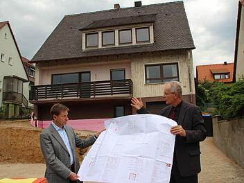 Das steile Satteldach in der Mayer-Franken-Straße 81 muss bleiben. Bevor der Bauausschuss das am Montag beschloss, machten sich die Räte vor Ort ein Bild. Stadtrat Reinhold Otzelberger (SPD) und Bauamtschef Gerhard Zedler (rechts) mit dem Bauplan.  Foto: Roepert