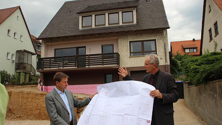 Das steile Satteldach in der Mayer-Franken-Straße 81 muss bleiben. Bevor der Bauausschuss das am Montag beschloss, machten sich die Räte vor Ort ein Bild. Stadtrat Reinhold Otzelberger (SPD) und Bauamtschef Gerhard Zedler (rechts) mit dem Bauplan.  Foto: Roepert