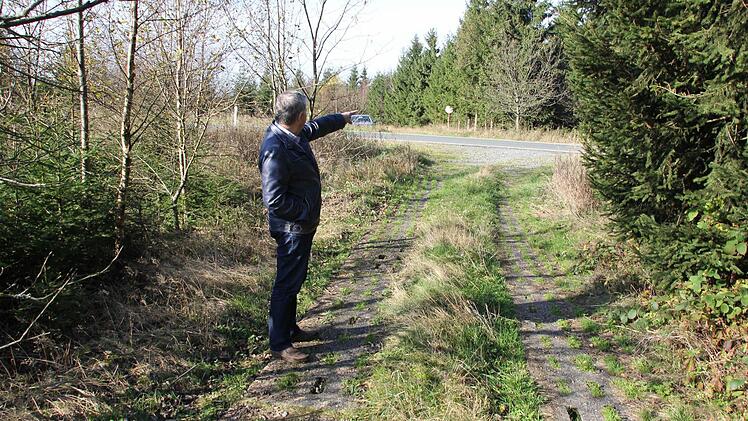 Adelbert Greiner auf dem Kolonnenweg. Er zeigt auf die Stelle, wo sich am Straßenrand im Hintergrund der DDR-Beobachtungsturm befand.