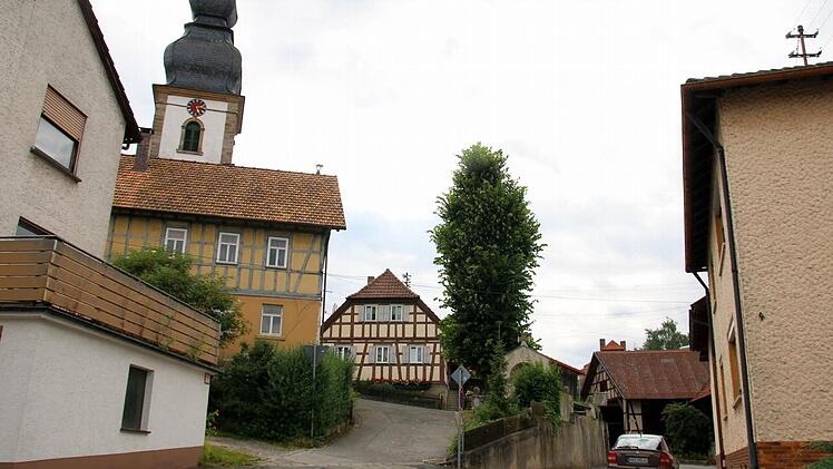Im Zuge des Ausbaus der Bergstraße in Autenhausen lässt das Landratsamt auf Höhe der Kirche eine neue Stützmauer errichten. Für diese müssen das Kriegerdenkmal versetzt und die Linde gefällt werden, informierten die Verantwortlichen bei einer Bürgerversammlung im Sportheim. Weil ein Gehweg die Verkehrssicherheit in der Engstelle verbessern soll, wird zukünftig eine Ampel den Begegnungsverkehr dort auf ein Minimum reduzieren. Foto: Bettina Knauth