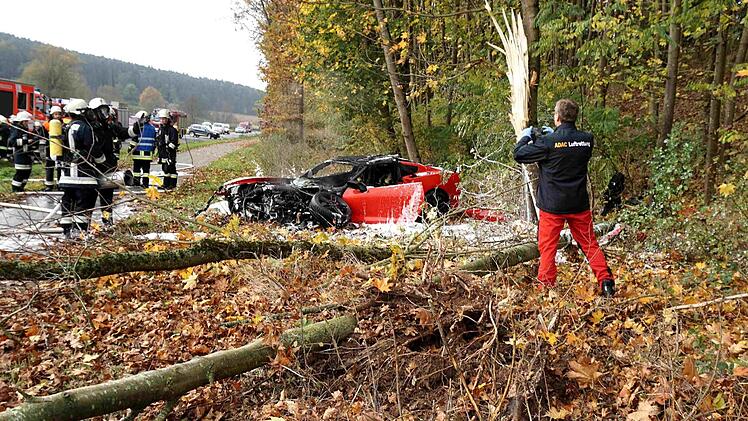 Bei Neundorf ist ein Auto von der Fahrbahn abgekommen und ist am Waldrand in Brand geraten.  Foto: Richard Sänger