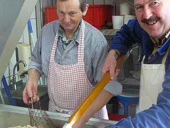 Helmut Baumer (links) und Franz Ott nehmen das gekochte Fleisch aus dem Kessel, um es Klaus Witzgall, Winfried Baumgärtner und Matthias Kummer zum Zuschneiden für den Pressack zu reichen. Fotos: Klaus-Peter Wulf