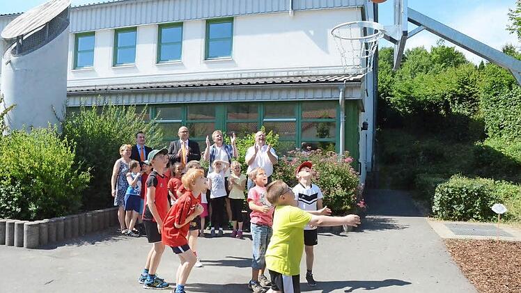Sie verfolgen den Weg der ersten Bälle in das Basketballkorbnetz: (hinten von links Edeltraud Höhn (Leiterin Mittagsbetreuung), Steffen Matuschek, Michael Engelhardt (Raiffeisenbank Obermain-Nord), Schulleiter Ralf Knöchel und Bürgermeister Egon Herrmann. Foto: Karl-Heinz Hofmann