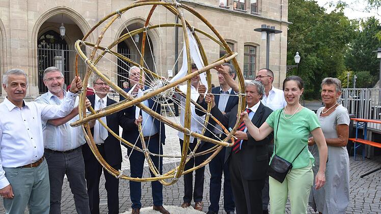 Bänder, die mit Friedensbotschaften beschriftet waren, verknoteten Vertreter aus Religion und Politik zu einer Friedenskugel. Foto: Gabi Arnold