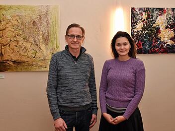Die Künstlerin Olga Liashenko aus Haßfurt stellt derzeit im Weinhaus Schaffner in Haßfurt einige ihrer Gemälde aus. Links neben ihr steht Inhaber Renée Büchner.Ulrike Langer