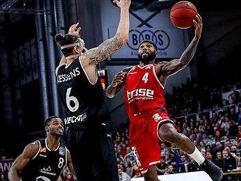 Bambergs Tyrese Rice steigt zum Korbleger gegen Vechtas Center Michael Kessens hoch; links Aufbauspieler Josh Young. Daniel Löb