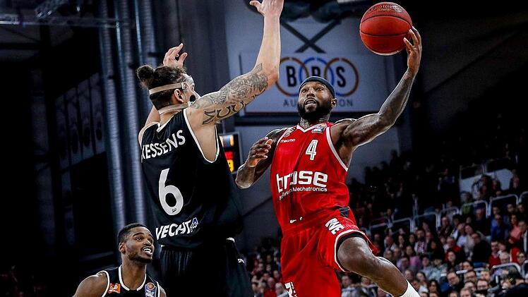 Bambergs Tyrese Rice steigt zum Korbleger gegen Vechtas Center Michael Kessens hoch; links Aufbauspieler Josh Young. Daniel Löb