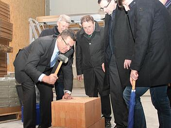 Staatssekretär Franz Josef Pschierer nimmt den Gummihammer zur Hand und arbeitet den Mauerstein fest in das Mörtelbett ein. Mit innovativen Mörtelplatten will Franken Maxit den Markt erobern. Mit im Bild (von links) Firmenchef Hans-Dieter Groppweis, Kulmbachs OB Henry Schramm, MdL Martin Schöffel und Juniorchef Sebastian Groppweis. Fotos: Alexander Hartmann