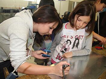 Lisa Schmidt ist im zweiten Lehrjahr. Sie zeigte den Girls'-Day-Teilnehmerinnen bei der Kulmbacher Firma Glen Dimplex, wie man richtig lötet. Raphaela Meisel (11) aus der fünften Klasse der Max-Hundt-Schule fand das interessant. Sie interessiert sich sehr für Technik. Foto: Sonja Adam